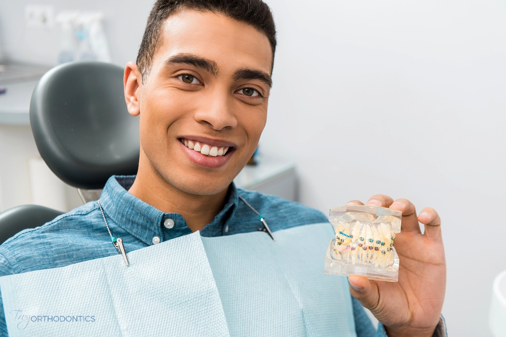 a man holding dental model after being explaned about how long do braces take in little falls, nj